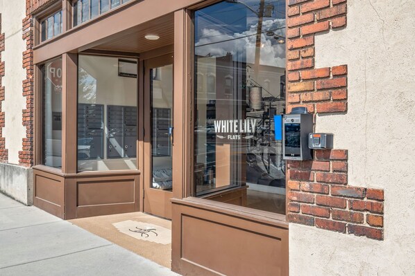Un escaparate con un amplio ventanal y un letrero que dice "WHITE LILY FLATS".