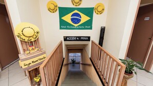 A staircase with a Brazilian flag and a sign reading "ACESSO à PRÁIA". - Pousada Terra do Sol Natal (Natal)