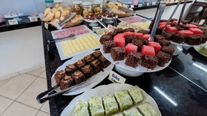 A buffet with various desserts including brownies, cakes, and pastries. - Pousada Terra do Sol Natal (Natal)
