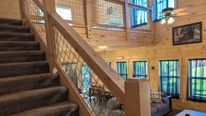 A wooden interior with a carpeted staircase, a dining area, and large windows. - 3 Master Suites, Easy Access w/View, Game&Theater Rms, Fire Pit, & Pool Access (Sevierville)