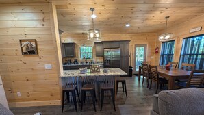 A cozy cabin interior with a kitchen, dining area, and seating space. - 3 Master Suites, Easy Access w/View, Game&Theater Rms, Fire Pit, & Pool Access (Sevierville)