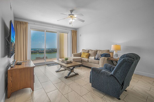 A modern living room with a sofa, armchair, coffee table, and a flat-screen TV. - Ariel Dunes II 907 *Beach views *Pools* (Miramar Beach)