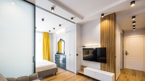 A modern bedroom with a bed, a TV, and a sliding door closet. - Tribunali Trendy Apartment by Wonderful Italy (Naples)