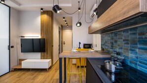 A modern kitchen with a wooden countertop, a built-in stove, and a blue-tiled backsplash. - Tribunali Trendy Apartment by Wonderful Italy (Naples)