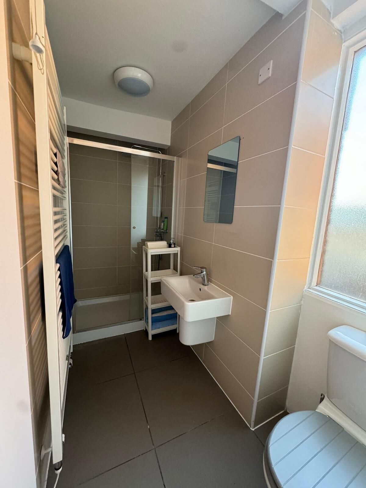 A bathroom with a white sink, a mirror, and a shower area.