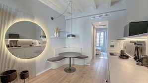 Une cuisine moderne dotée d’un îlot central, de luminaires suspendus et d’un grand miroir.
