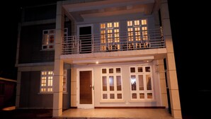 A two-story building with a balcony, large windows, and a door. - Kilimanjaro Foothills Getaway (Marangu)
