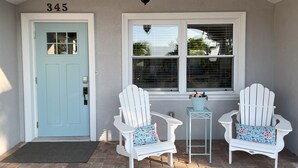 A porch with two white Adirondack chairs, a light blue door with the number 345, and a window with blinds. - Stroll to the Sea, Steps to the Village!
Boat Docking, Kayaks, Heated Pool & Spa (sarasota)
