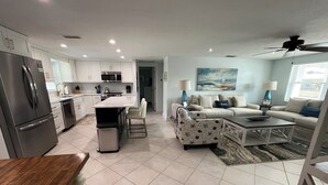 A modern kitchen with stainless steel appliances, a dining area with a wooden table, and a living room with a sofa and a coffee table. - Stroll to the Sea, Steps to the Village!
Boat Docking, Kayaks, Heated Pool & Spa (sarasota)