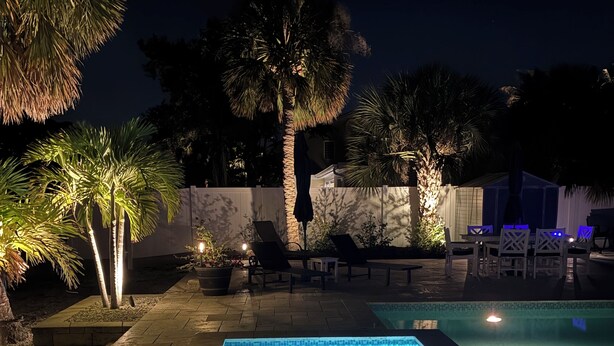 A rectangular swimming pool with a tiled edge, surrounded by a stone deck, and adjacent to a white fence. - Stroll to the Sea, Steps to the Village!
Boat Docking, Kayaks, Heated Pool & Spa (sarasota)
