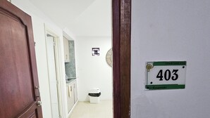 A hallway with a door on the left, a trash bin, and a wall-mounted sign indicating room number 403. - Apartment on the 4th floor with beautiful views by Parceros Group (Cartagena)
