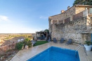 Relax by the pool surrounded by a tranquil outdoor space.