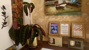 Ein Zimmer mit einem großen Gemälde von Booten, einer Topfpflanze und mehreren gerahmten Schildern an der Wand.