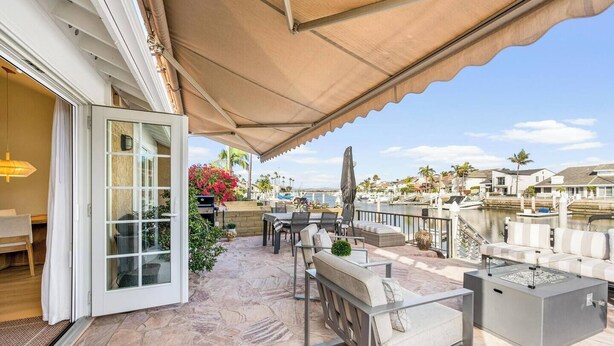 Un patio con mobiliario exterior, una parrilla y vistas al puerto deportivo.