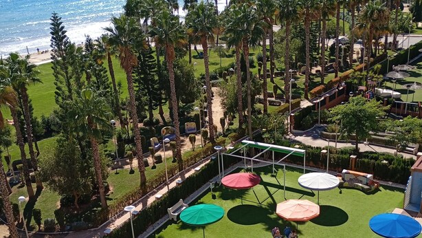 A pool area with multiple umbrellas, a small pool, and a view of the ocean. - Apartamento de luxe Frontal al mar (Oropesa del Mar)