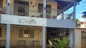 A two-story building with a sign for 'Suites Boa Vagem' and a gated entrance. - Suites Boa Viagem (Pirenópolis)
