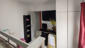 A compact kitchen with a refrigerator, a microwave, and a small dining table.