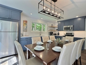 Enjoy cooking in this well-equipped kitchen with a central island, stainless steel appliances, and a dining area.