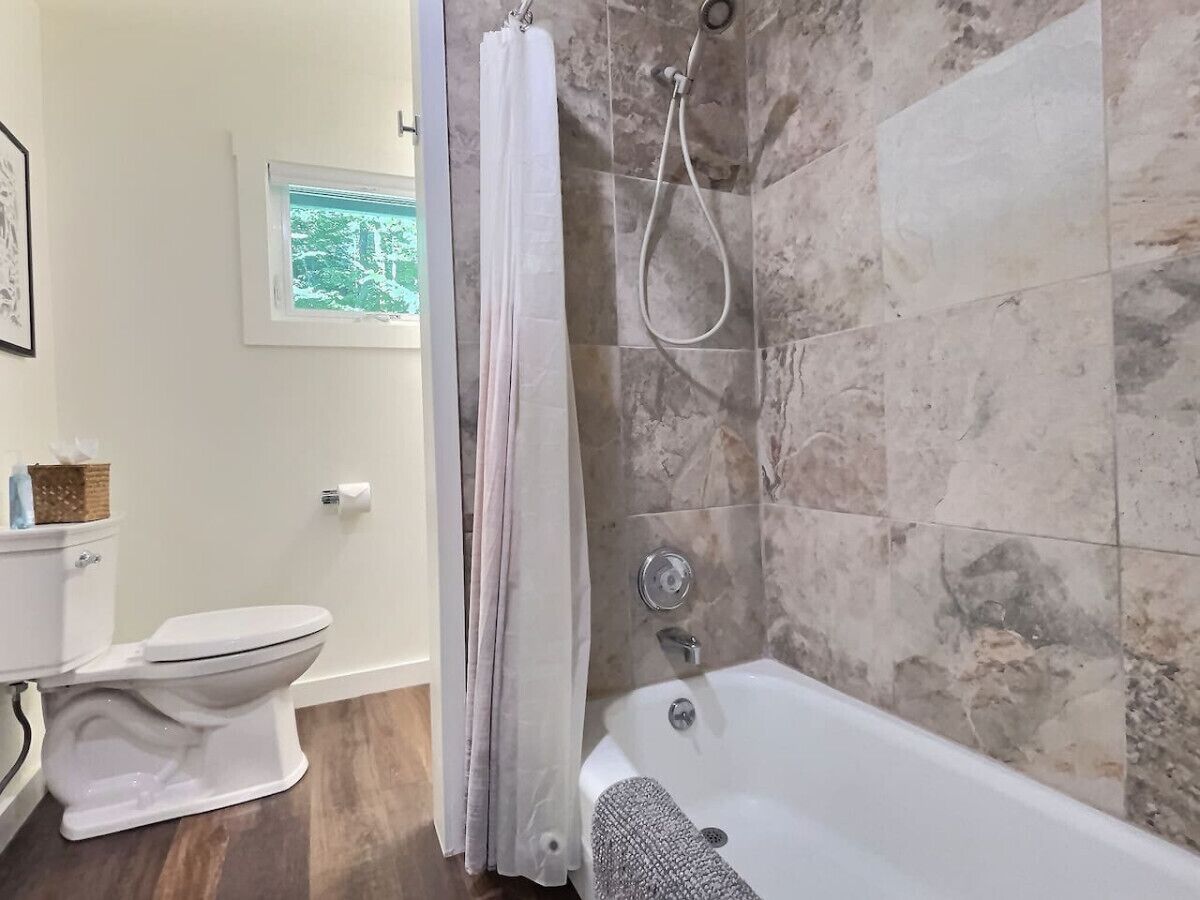 Une salle de bain équipée de toilettes, d’une baignoire et d’une douche.