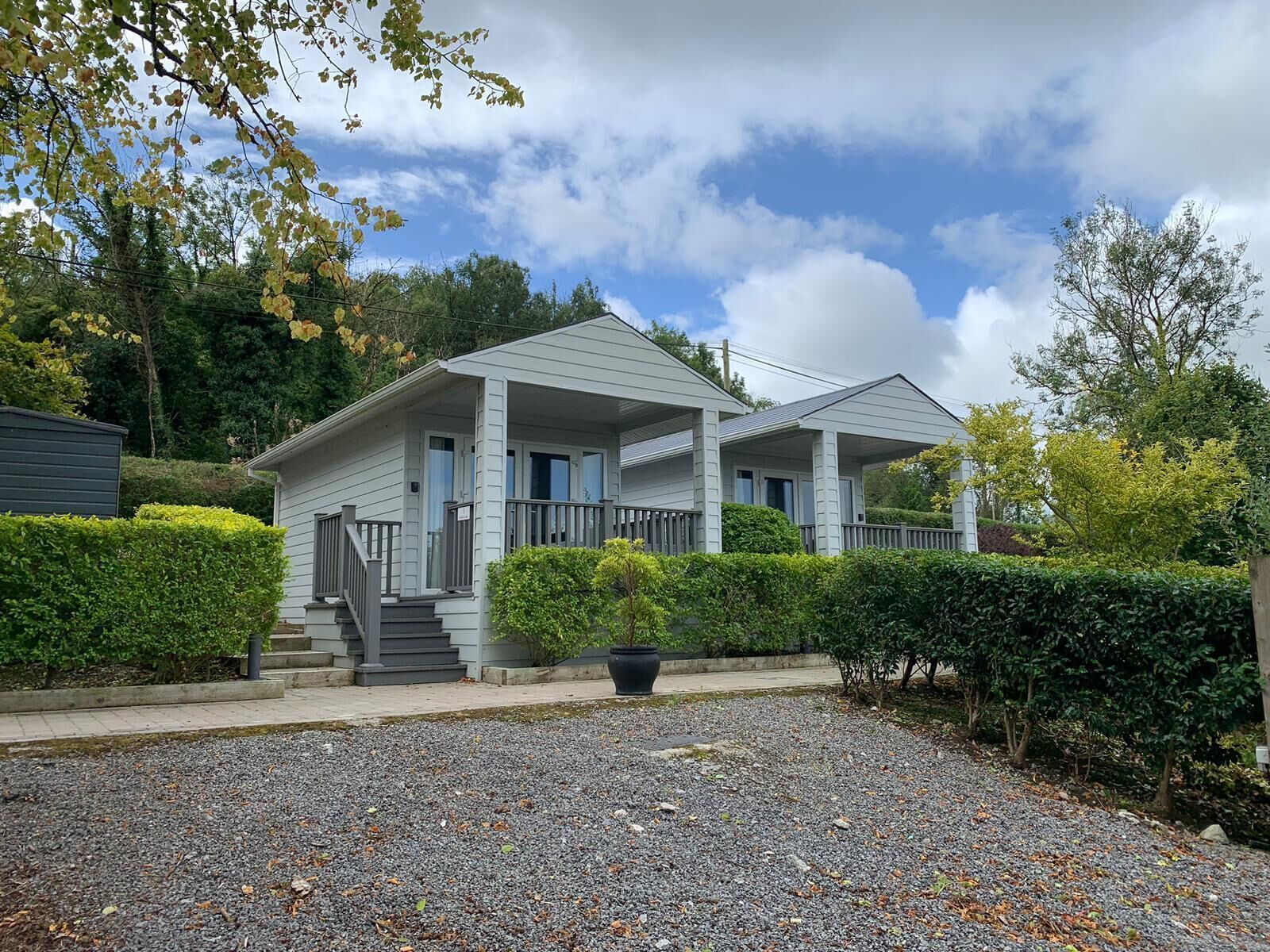 A two-story house with a front porch, a covered entryway, and a gravel driveway.