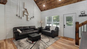 Una sala de estar moderna con un sofá modular, una mesa de centro y un techo de madera.
