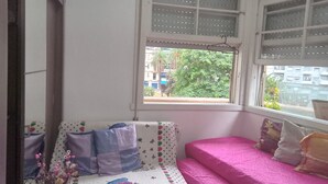 A room with a bed, a window, and a mirror.