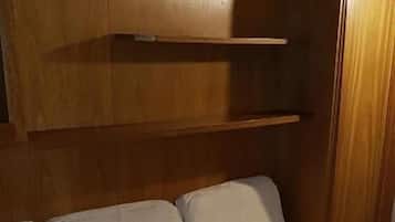 A wooden bed with a headboard and a built-in storage drawer.