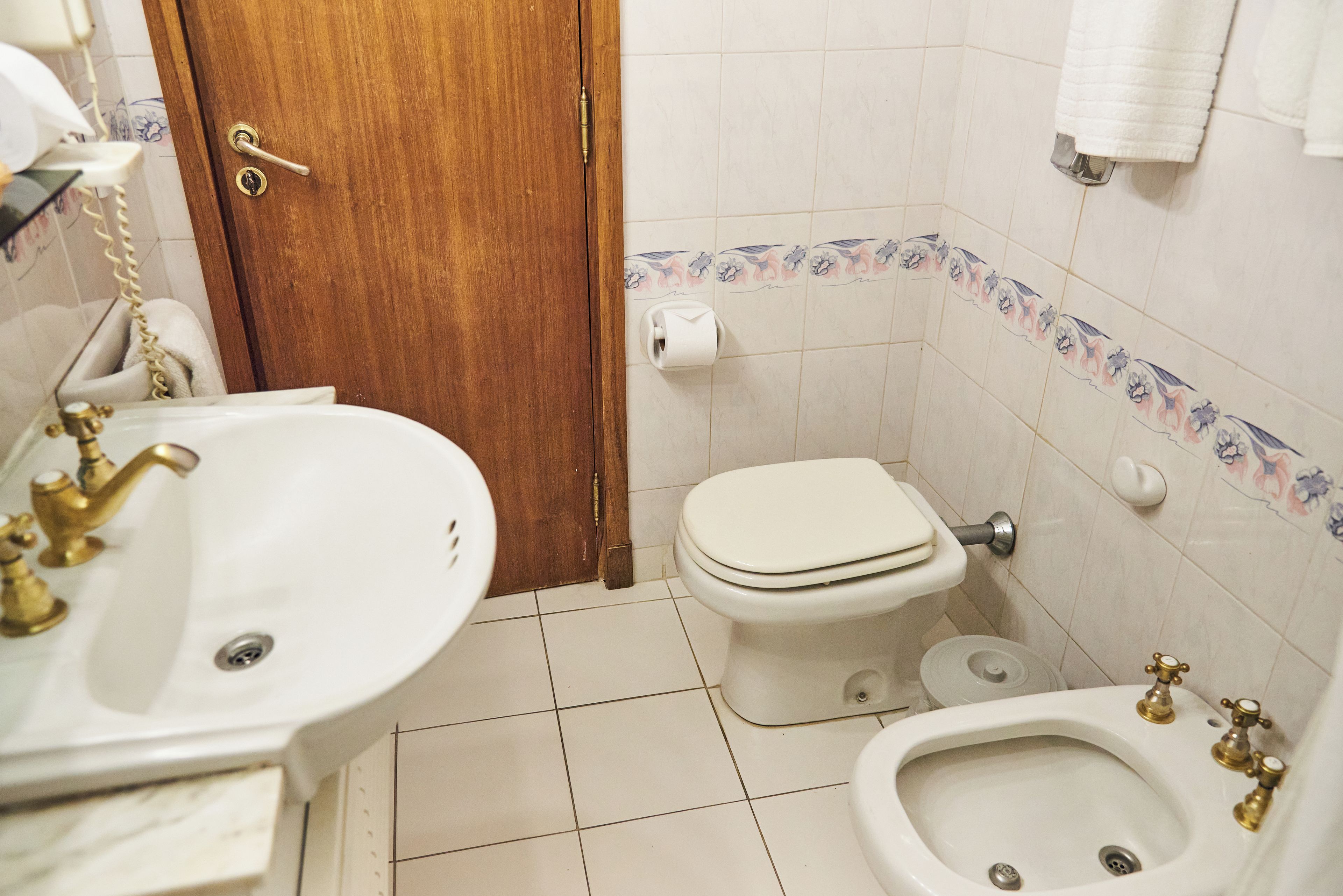 Une salle de bain équipée de toilettes, d’un bidet et d’un lavabo.