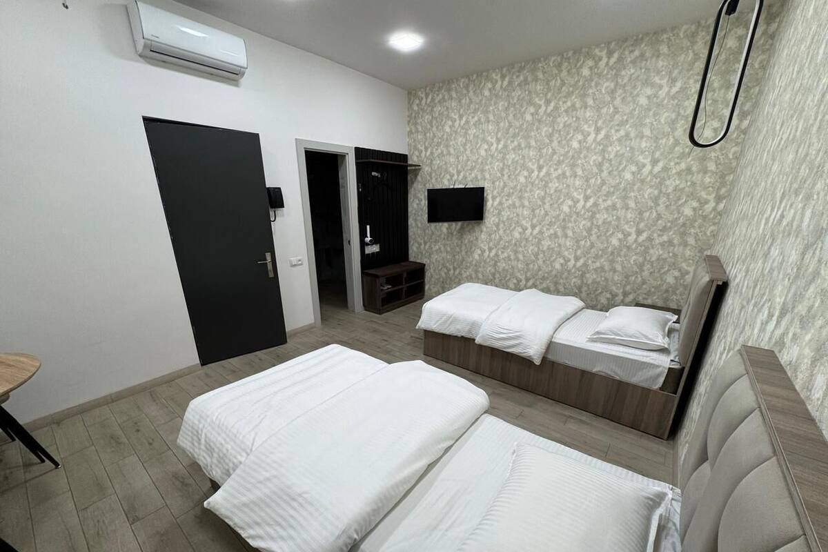 Una habitación de hotel con dos camas, un televisor y un armario.