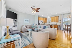 A spacious living room with a sofa set, a coffee table, and a dining area with a table and chairs.