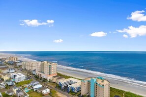 A coastal residential area with beachfront properties, including multi-story buildings and single-family homes.