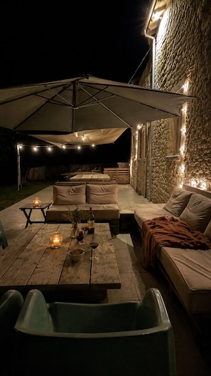 An outdoor seating area with a table, chairs, and a large umbrella.