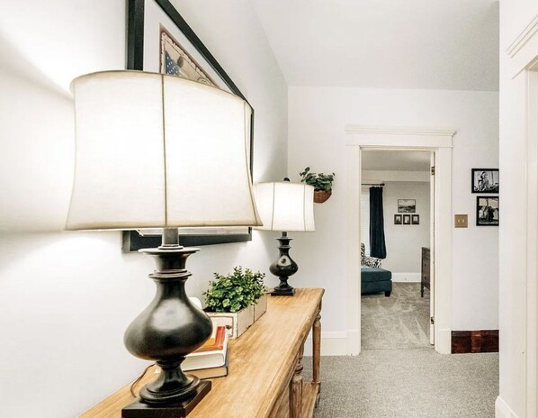 A hallway with a wooden bench, two lamps, and a small plant. - Blue Jay - Charming Upper Level Duplex Near Downtown (Great Falls)