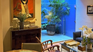 A dining area with a wooden table, chairs, and a painting on the wall. - Parque Juan Diego (Zapopan)