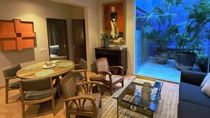 A modern living room with a dining area, a sofa, a coffee table, and a large window with a view of palm trees. - Parque Juan Diego (Zapopan)