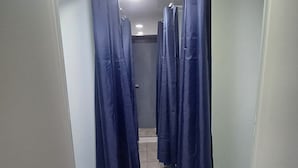 A corridor with multiple blue curtains, a tiled floor, and a plain wall. - Ocean's Guesthouse - foreigners only (Seoul)