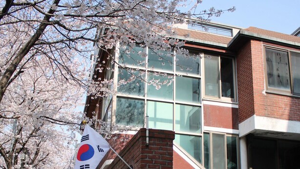 A building with a red brick facade, large windows, and a sign indicating a Korean restaurant. - Ocean's Guesthouse - foreigners only (Seoul)