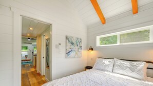 Ein Schlafzimmer mit einem großen Bett, einem Bild an der Wand und einem Fenster.