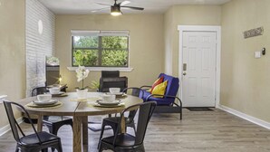 A dining area with a round table, black chairs, and a ceiling fan.