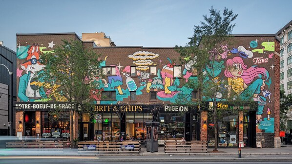 A building with colorful murals, including a fox and a bear, and storefronts for 'Brit & Chips' and 'Pigeon'.