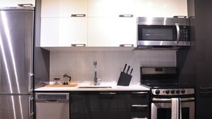 Eine moderne Küche mit Edelstahlgeräten, darunter ein Kühlschrank, eine Mikrowelle und ein Backofen.