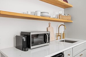 Coffee/tea maker, microwave, cookware/dishes/utensils, dining tables