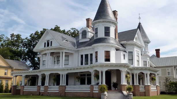A large, white, two-story house with a prominent tower and multiple windows. - Cedar Grove Cottage Conveniently Located to all attractions. (New Bern)