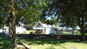 A residential area with houses, a grassy lawn, and a stone wall. - Cedar Grove Cottage Conveniently Located to all attractions. (New Bern)