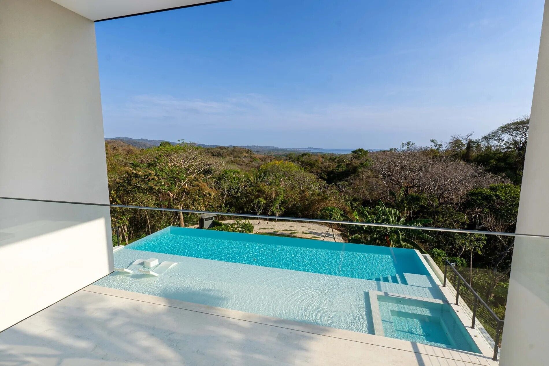 A modern infinity pool with a clear view of the surrounding landscape.