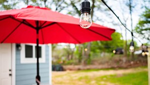 A patio with a red umbrella, a table, and chairs. - Marietta Square's Home Away! (Marietta)