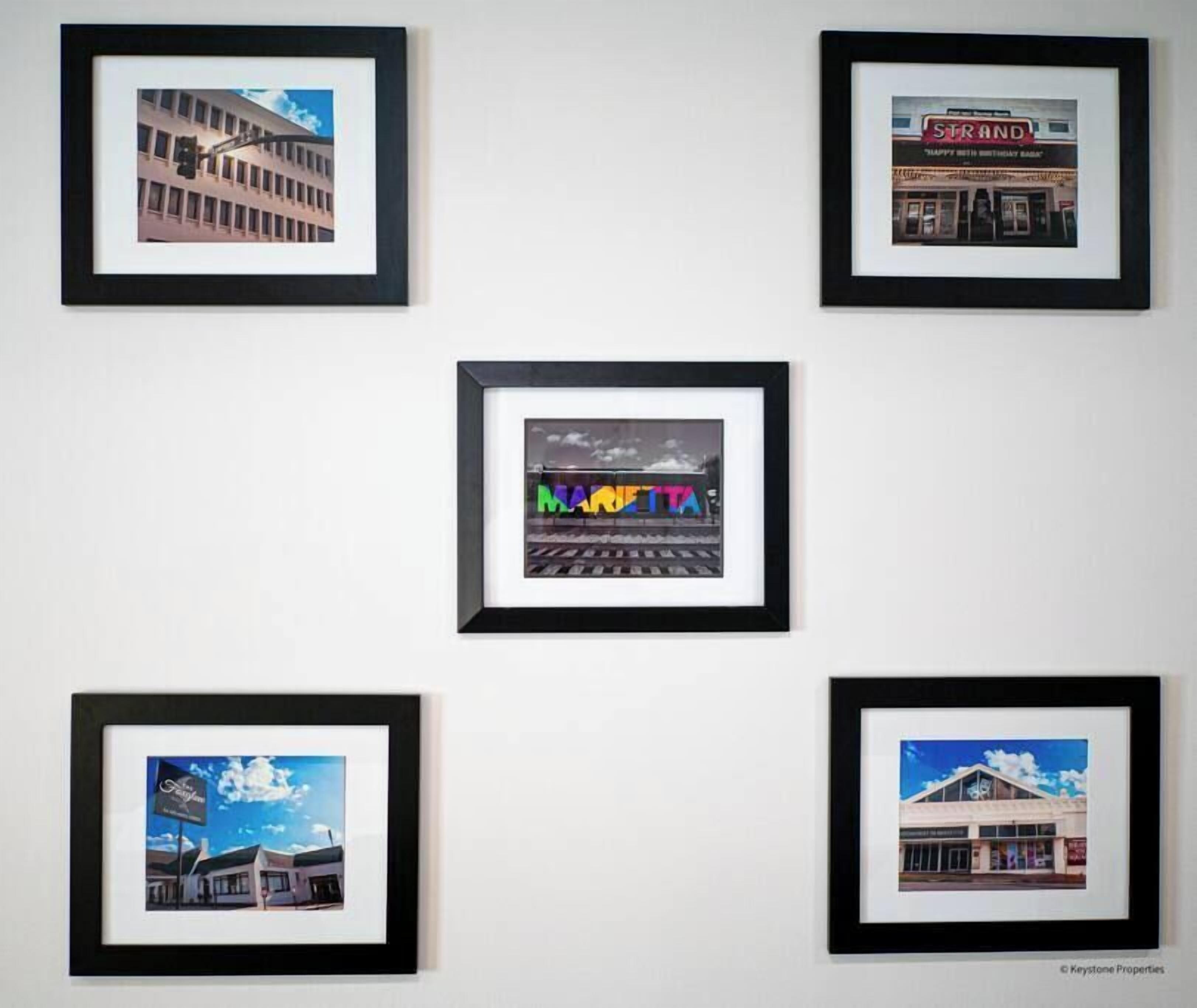 A series of framed photographs of buildings, including a cinema and a train station.