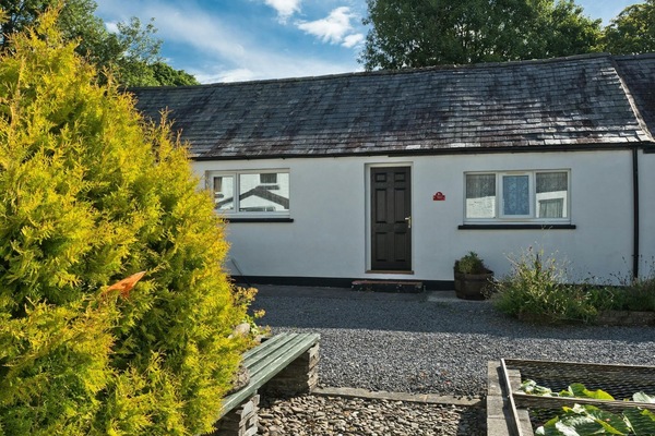 Front of cottage leading to gravel area and fish pond