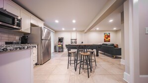 A modern kitchen with a built-in microwave, stainless steel refrigerator, and a coffee bar sign. - The Grand Slam - The Battery ATL (Smyrna)