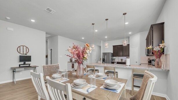 A modern kitchen with dark cabinets, a central island, and pendant lighting.